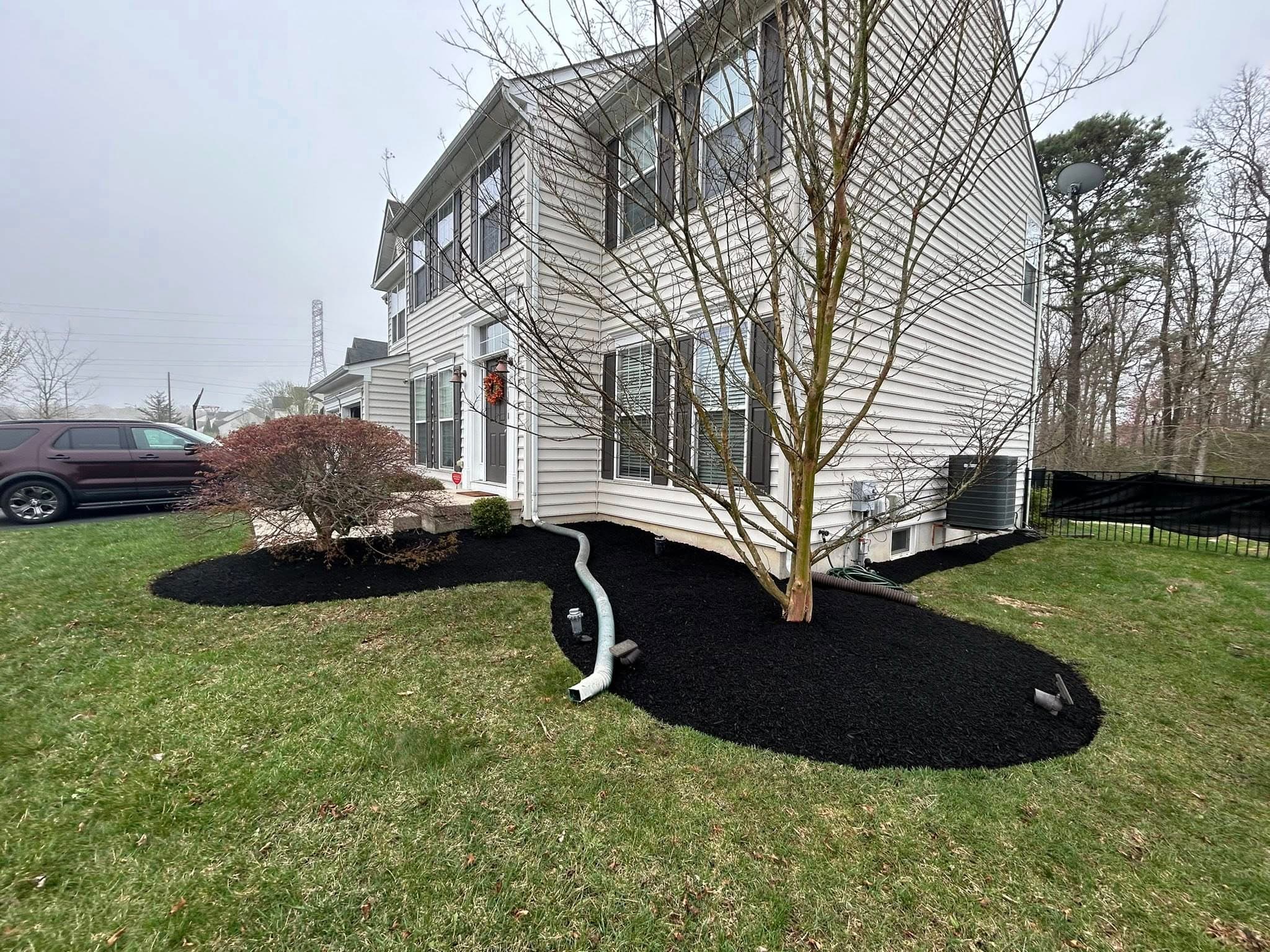 Black mulch landscaping around a home's exterior, enhancing curb appeal and garden design.